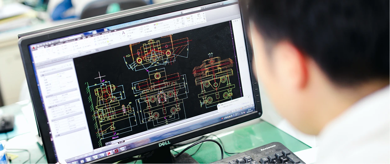 オフィスのパソコンで設計図を制作する設計職の写真