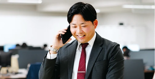 オフィスで顧客と電話をする営業職の写真